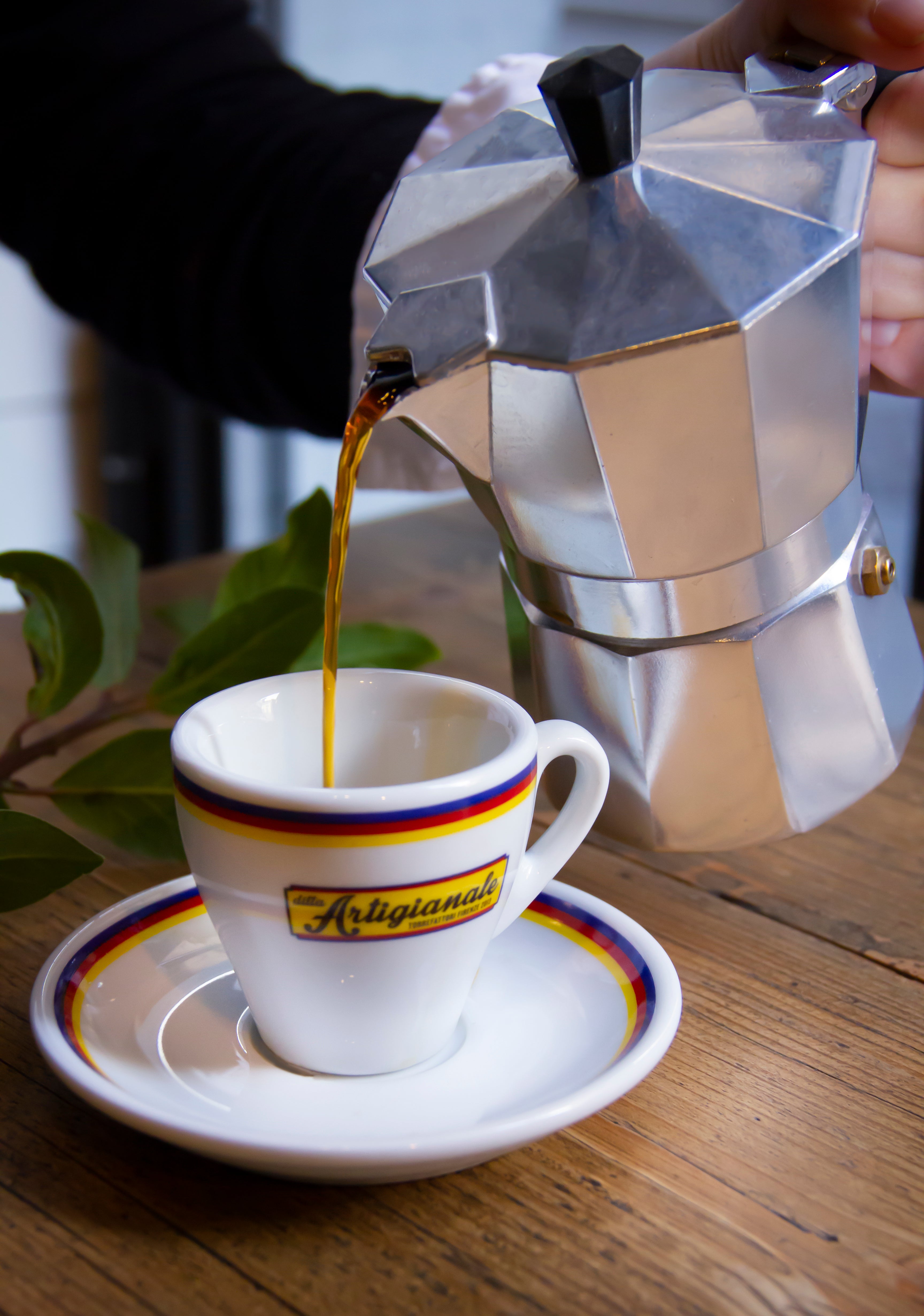 Tazza di ceramica artigianale con caffè specialty appena preparato con la moka. La caffettiera moka è posizionata accanto, creando un'atmosfera calda e autentica, che richiama il piacere del caffè fatto in casa con cura e passione.